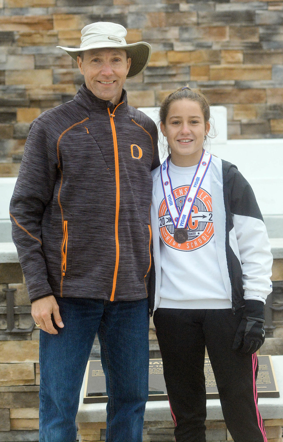 Coach Matt Candrl (left) poses with Limberg after presenting her with her 18th-place medal at Gans Creek.